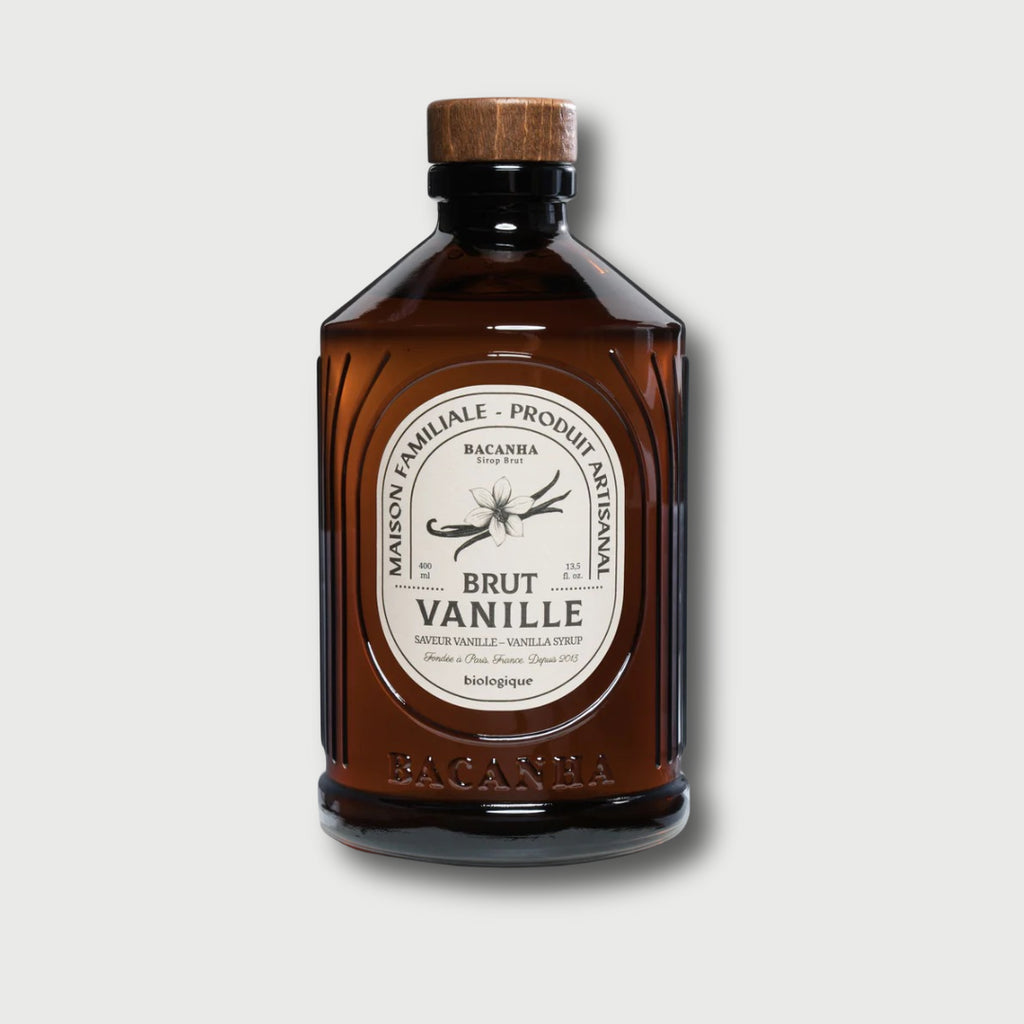 Brown glass Brut Bacanha Vanilla bottle with wooden cap on a light gray background