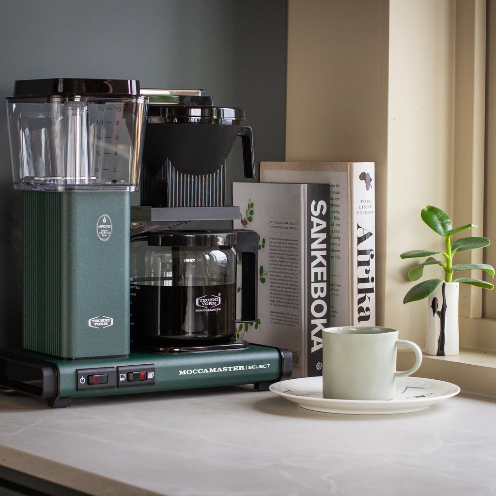 Moccamaster KGB Select Forrest Green Lifestyle Foto met boeken , planten en keramieke kopjes